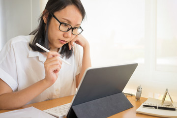 Businesswoman tired from working with digital tablet and overtime workload at the home office. Using smartphone tablet, Freelance Work, Business, Relax Sleeping and taking nap concept.