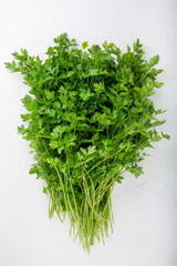 Bunch of parsley on white background. Fresh organic herbs. Top view, close-up.