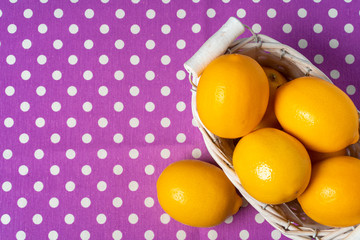 Basket of lemons on dotted purple tablecloth