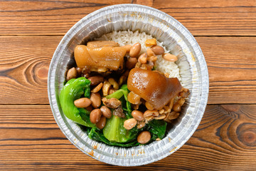 top view pork knuckle with rice as a take out fast food on wood table