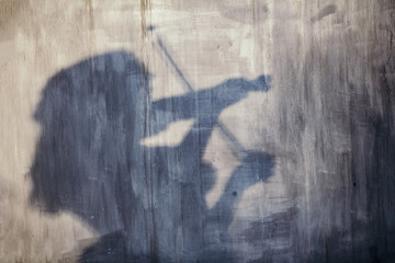 shadow of a violinist on a painted texture, the figure of a girl with a musical bow instrument, a...