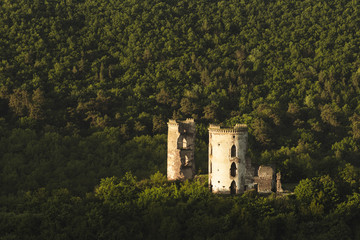 Fototapeta premium Remnants of the medieval old castle of the cylindrical form in the hilly valleys of western Ukraine, travel, historical values