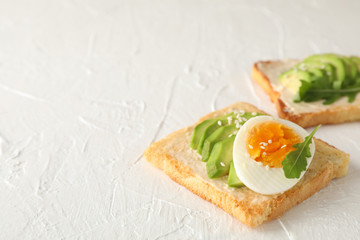 Toasts with avocado and egg on white background, close up