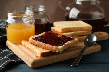 Toasts, jam and tea on wooden background, close up