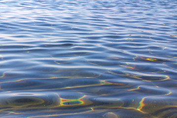 Background of sea coastal water with a sandy bottom and reflection of sun glare