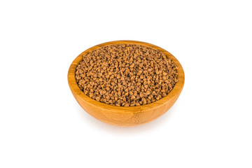Raw buckwheat groats in a bamboo cup isolated on white with a light shadow. Diet Food Concept.