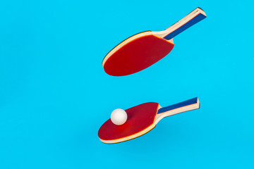 Red ping pong racket on a blue background