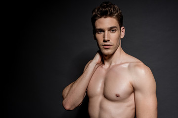 Fototapeta premium sexy young naked man with muscular torso posing on black background
