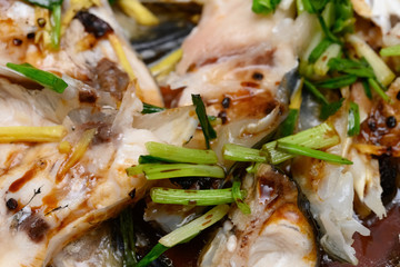 fresh steamed fish covered with herbs onions and sauce