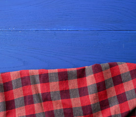 red checkered fabric on a blue wooden background