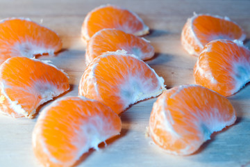 many tangerine slices on wooden background