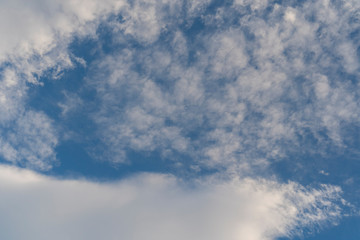 Beautiful cirrus and cumulus clouds on a bright blue sky. Colorful positive natural landscape