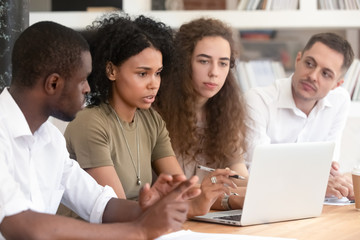 Focused multiracial group discuss business ideas together