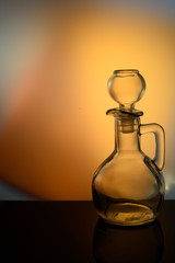 glass carafe on a flickering background a yellow background.