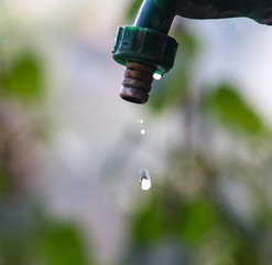 Small stream of water flowing slowly from a single tap