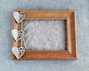 Wooden heart on crumpled paper in a frame