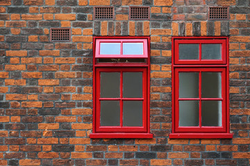 old stone wall with red window in england uk