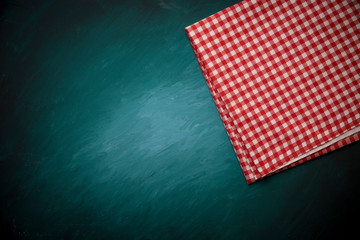 Fototapeta na wymiar Top view of checkered kitchen tablecloth on concrete background.