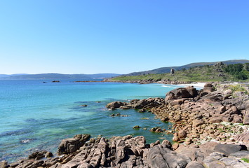 Fototapeta na wymiar Bay with beach, turquoise water and blue sky. View from the rocks. San Pedro Beach also known as O Pindo Beach. Carnota, Coruña, Galicia, Spain.