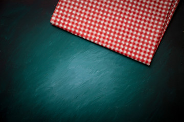 Fototapeta na wymiar Top view of checkered kitchen tablecloth on concrete background.