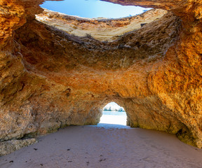 Natural caves in the impressive cliffs of Algarve coast in Portugal in summer