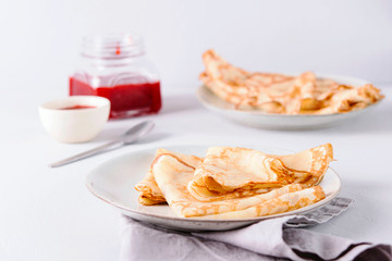 Crepes with strawberry jam on grey background. Pancake week, mardi gras, maslenitsa holidays. Selective focus