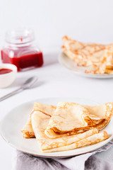 Crepes with strawberry jam on grey background. Pancake week, mardi gras, maslenitsa holidays. Selective focus