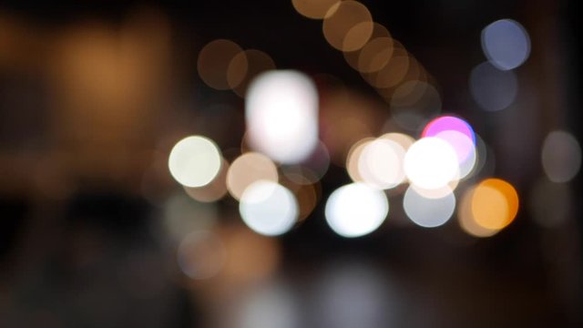 Beautiful glittering bokeh in dark blurry background at night. The round colorful bokeh shine from car lights in traffic jam on city street. Out of focus with blurry. Unfocused city lights. Traffic