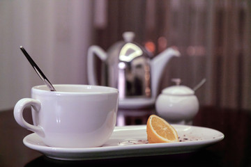dirty dishes and the rest of the lemon after tea drinking are on the kitchen table, blurred background