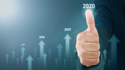 Obraz premium Man standing and pointing hand with Arrow and Line Visual Graphic on Light of Len flare and Boke blue background. COPY SPACE. Business Concept : Market Uptrend YEAR 2020.