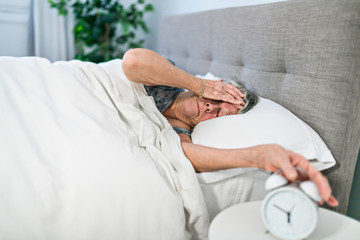 Obraz na płótnie Canvas A Senior woman having sleep disorder, lying in bed