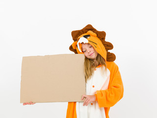pretty blonde girl with cozy lion costume is holding a brown sign in the studio in front of white wall
