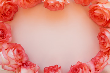Heart shape frame from fresh orange roses on pink background. Top view. Flat lay. Copy space....