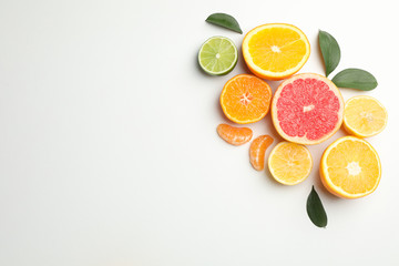 Citrus fruits and leaves on white background, space for text