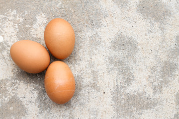Top view three brown eggs on concrete.