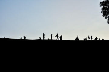 Fototapeta na wymiar Group of tourist on hill in morning time. Silhouette group of peoples on hill in morning time before sunrise