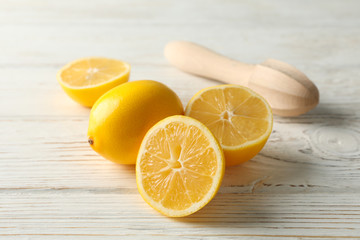 Lemons and wood juicer on wooden background, close up