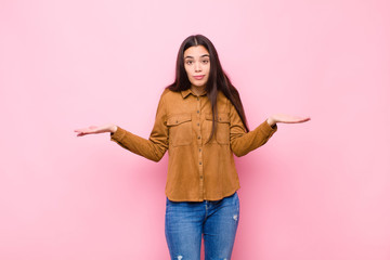 young pretty woman feeling puzzled and confused, unsure about the correct answer or decision,...
