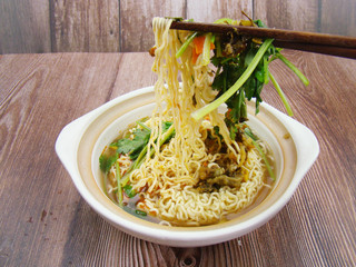 parsley Instant noodles  in a dish filled with boiling water.Chinese tableware