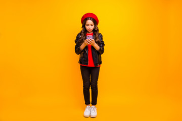 Full length body size view of her she nice attractive pretty lovely focused long-haired girl wearing streetstyle using cell gadget isolated over bright vivid shine vibrant yellow color background