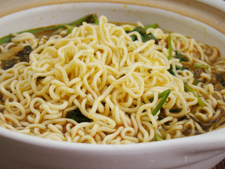 Lift the lid.Instant noodles  in a dish filled with boiling water.Chinese tableware