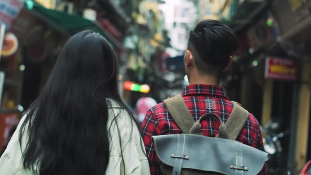 Handheld view of couple walking in the Vietnamese street 