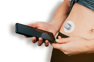 close up of female hands holding a mobile phone nearby a diabetes sensor - glucose monitoring...