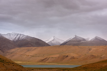 Ladakh landscape with snowy mountains and a long thread of buddhist flags