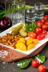 Assorted pickled vegetables pickled herring, chopped chives with potato, peppers, cucumbers, tomatoes, capers, salt and herbs. Set of vegetables snacks for alcohol vodka. Russian traditional cuisine.