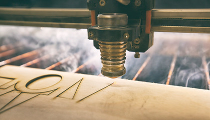 Laser cutting machine is cutting the wooden plank