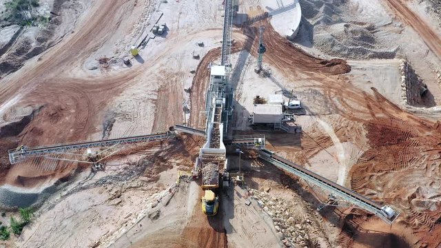 Aerial view of a large Quarry during work hours with Stone sorting conveyor belts and an open pit mine.