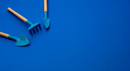 resource of gardening tools shovels and rake on blue classic background