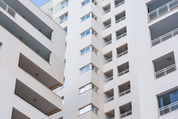 Inside corner of a multi-story residential building, close view of windows and balconies.