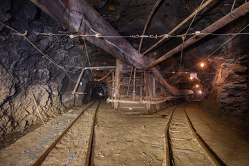 Fototapeta na wymiar Underground gold mine shaft tunnel drift with rails two ways